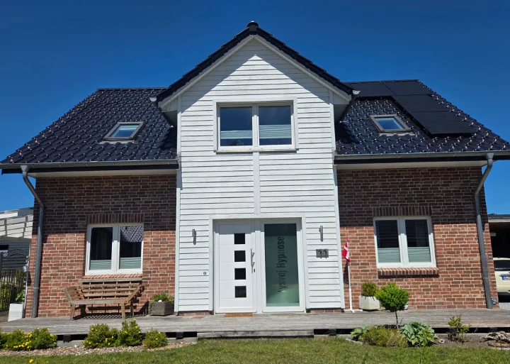 Ein Haus von außen, blauer Himmel, sonnenbeschienen